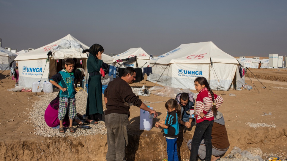 Newly arrived Iraqi families displaced from the Hay Sumer district of Mosul wash their hands at the UNHCR built Hasansham camp. 