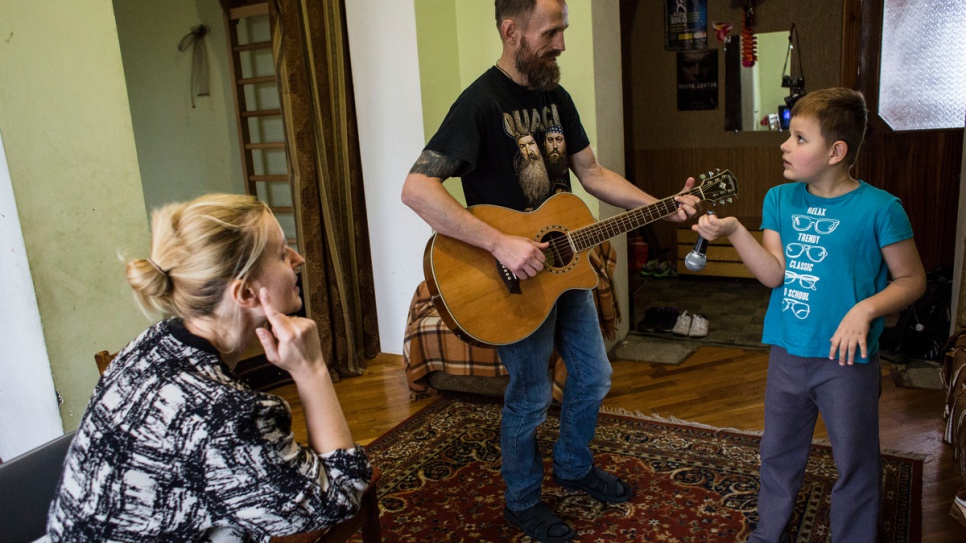 Anna, Gesha and Igor perform at home. Igor was born autistic and deaf, and is now learning sign language along with his mother.