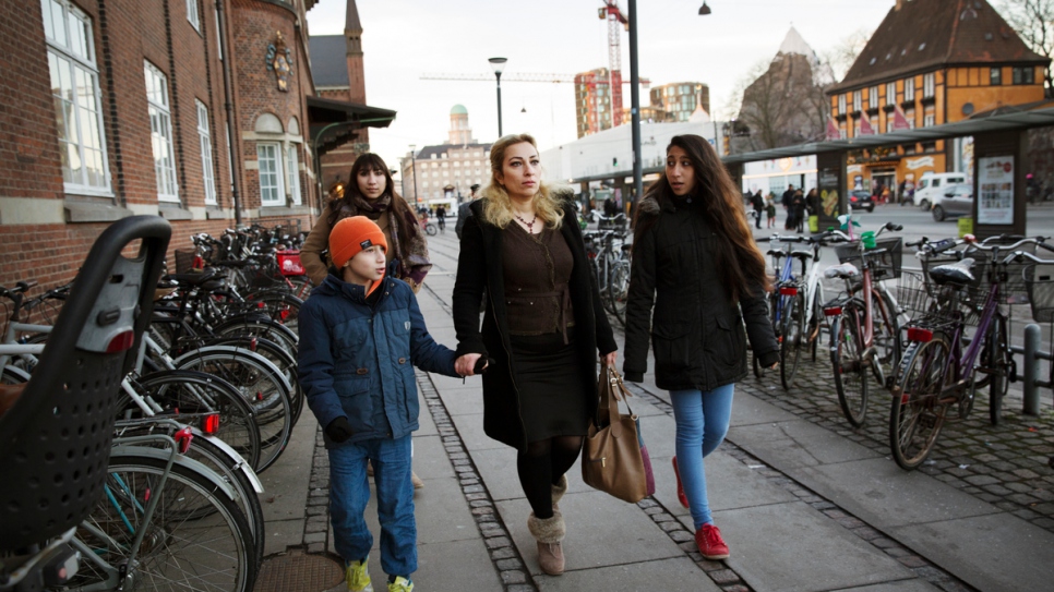 Manal walks with her three children through Copenhagen, Denmark.