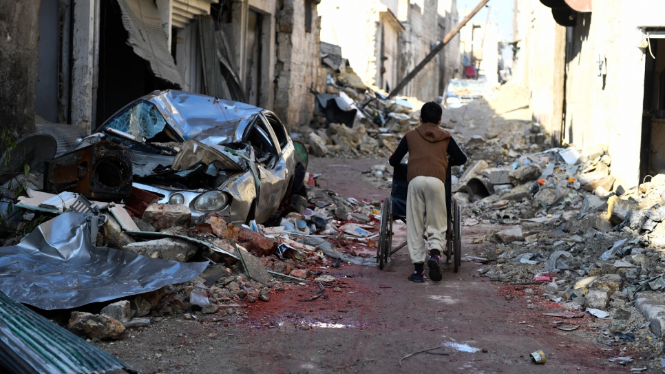 A boy pushes a wheelchair through the rubble on the streets of the Al-Mashatiyeh neighborhood in eastern  Aleppo.