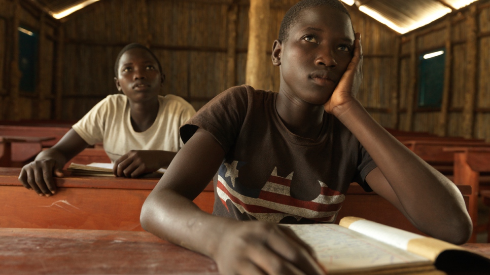 Dans une école du HCR établie pour les réfugiés, Tabu (à droite) et sa soeur jumelle Rena aiment aller à l'école. Mais selon Tabu, l'école est bondée et elle manque de manuels scolaires.