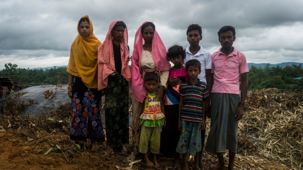 Rohingya refugees pose for a portrait in front of their new shelter at an informal settlement in Thangkali, Bangladesh.