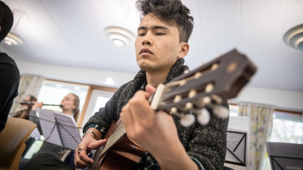 Afghan-born singer Amir Vafa, 20, plays the guitar during a rehearsal.