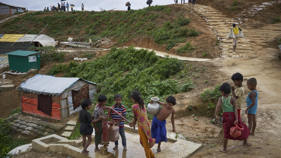 Rohingya refugee children queue to draw water from a well in Cox's Bazar District, Bangladesh, June 2018.