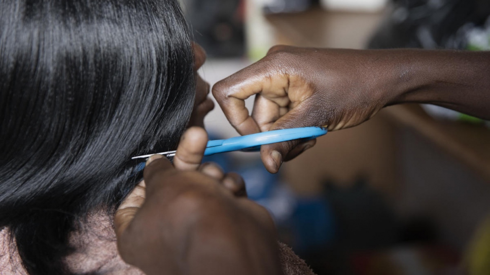 Une membre de l'association 'Standing Women' coupe les cheveux d'une cliente au salon de coiffure du groupe à Bangui, en République centrafricaine.  