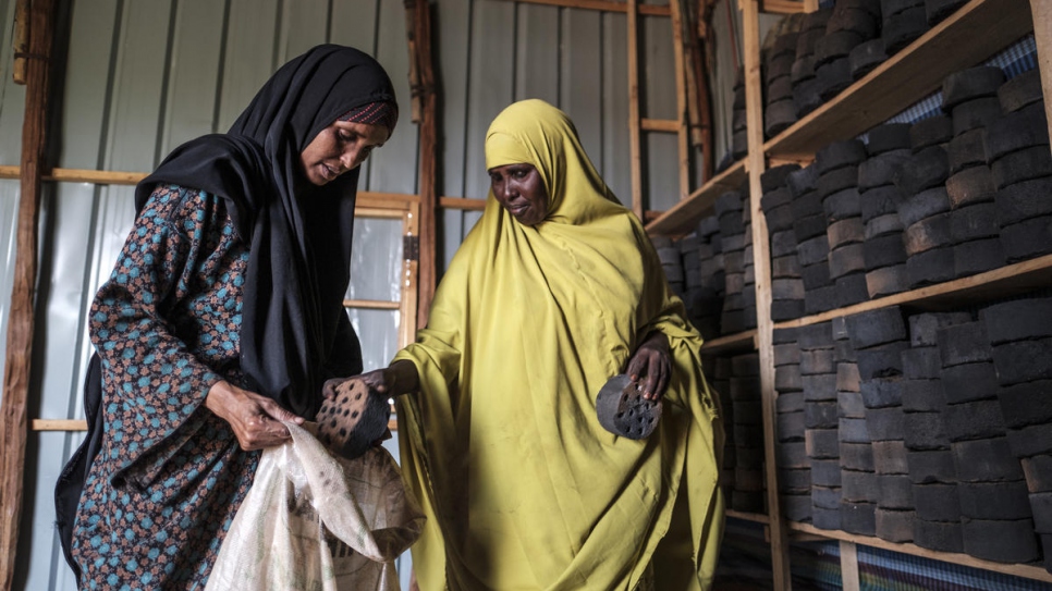 Somali refugee Asha Abdikadir Ahmed (left), 42, buys briquettes at the Prosopis Processing Centre in Bur Amino, Ethiopia.
