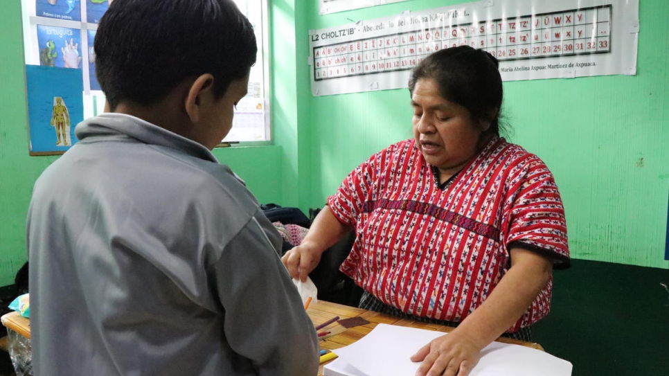 Le demandeur d'asile nicaraguayen Isai* (veste grise), âgé de huit ans, travaille avec son professeur de CE2 avant la fermeture de son école à la périphérie de Guatemala City. 