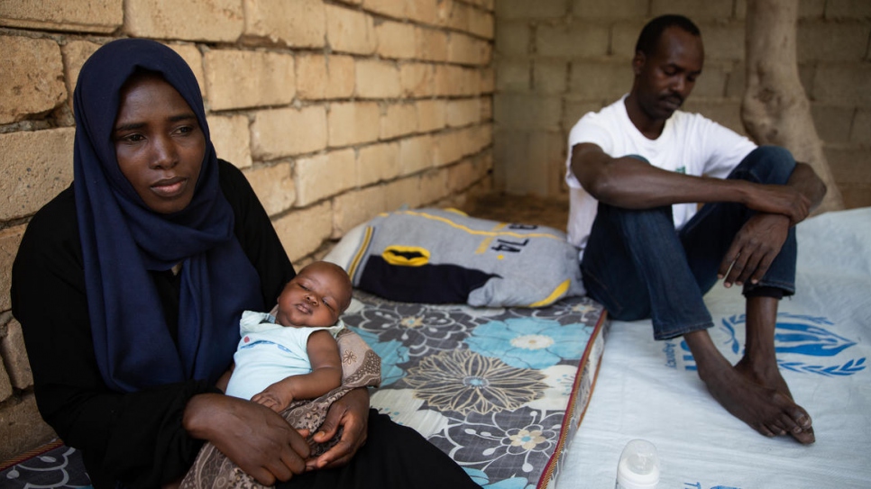 La nouveau-née Afnan s'assoupit dans les bras de sa Maman Halima devant leur maison à Tripoli, en Libye. 