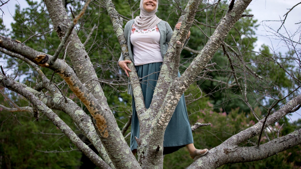 Rana Dajani climbs a tree near the house in Richmond, Virginia, where she was staying while Jordan's airport remained closed due to COVID-19.