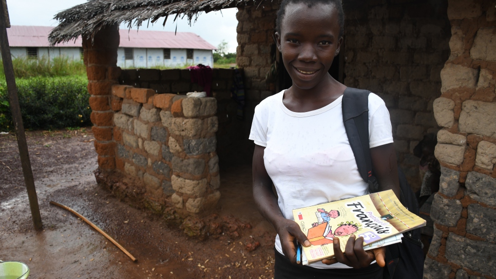 Une jeune réfugiée de 15 ans au camp d'Inke, en République démocratique du Congo (RDC), se prépare à une leçon répondant aux exigences de distanciation sociale donnée par un enseignant local, Jean Aimé Mozokombo.
