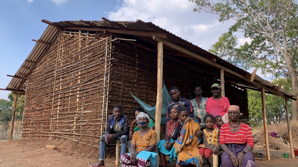 Joaquina* (wearing mask) sits with her family and relatives outside her brother's home in Montepuez after fleeing violent attacks in northern Mozambique.
