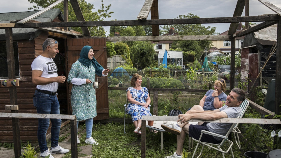 Ismael Khaled Jhayem (left) and his wife Ghofran have tea with members of the community support group, Paula Hobson, Tricia Brophy and Brian Hobson, at the couple's allotment, in Liverpool. Thingwall Allotments found a derelict plot that the family has already transformed into a thriving vegetable garden.