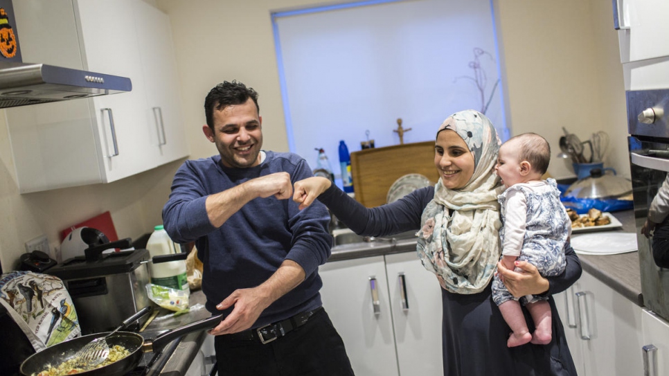 Hani Arnout, 34, and his wife Ameh, 23, cook with their five-month-old daughter Mary, in their new home in Ottery St Mary, Devon, south-west England.