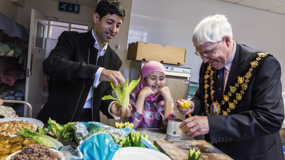 Muhaned Alchik and his daughter Sara, 8, help Mayor John Adams-Lewis to prepare Syrian food, at a church hall in Cardigan, Wales.