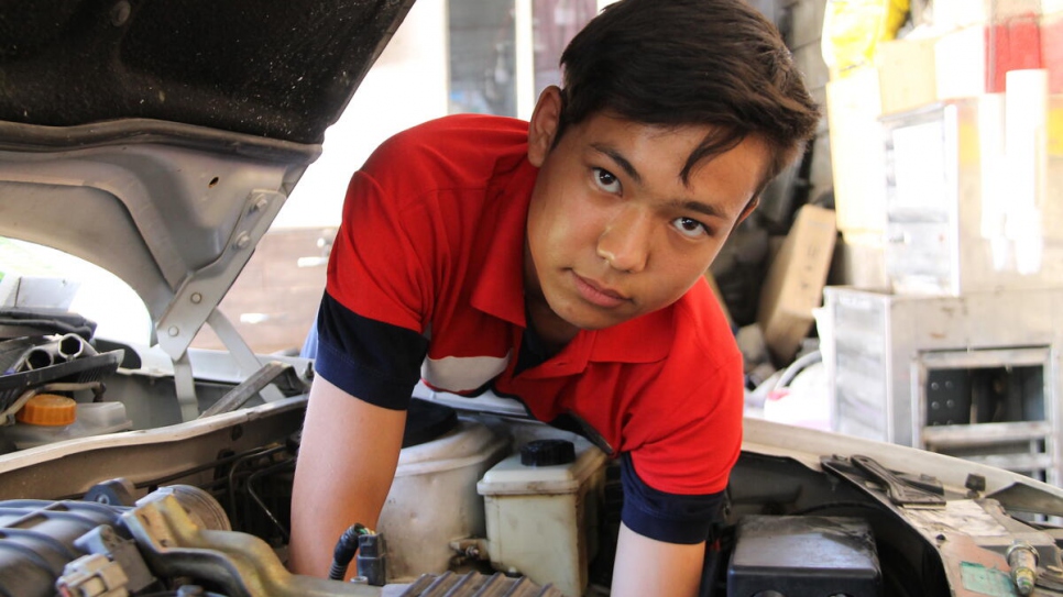 Soleiman, 18, is one of seven refugees who work at the repair shop alongside local Iranian mechanics.