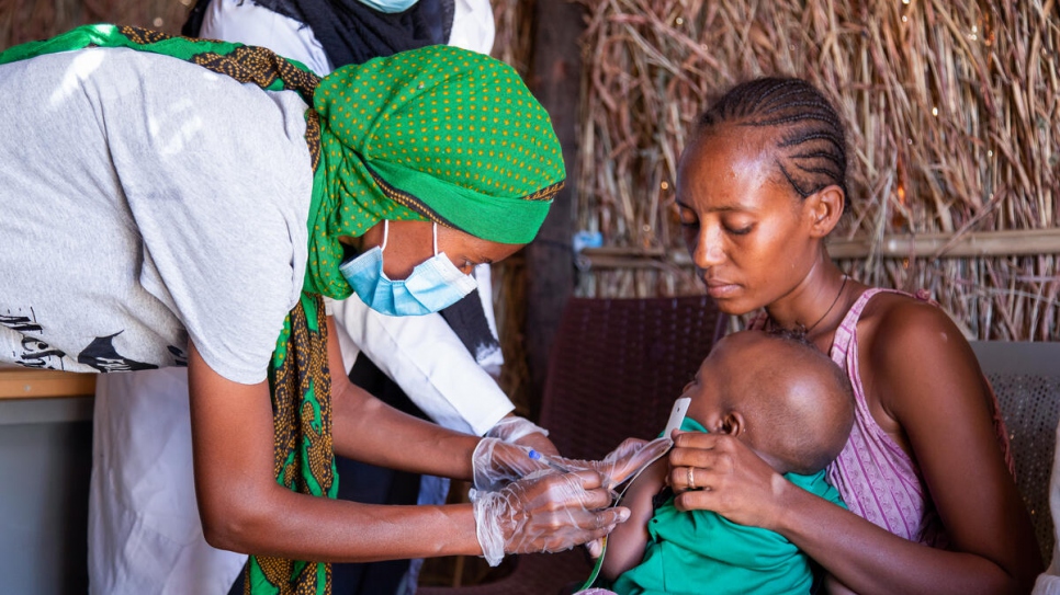 Ethiopian refugee Mihret, 25, takes details of a child at the clinic where she volunteers in Tunaydbah settlement, Sudan.  