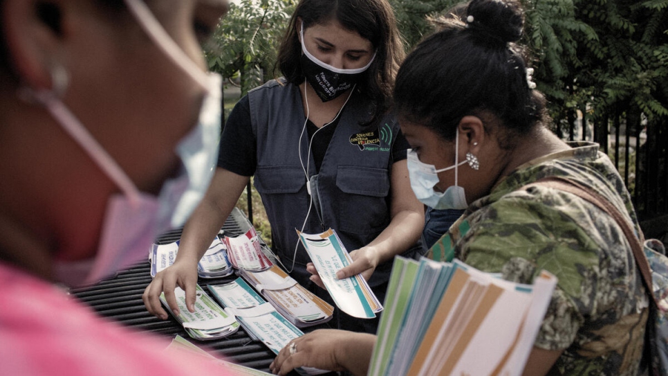 Volunteers distribute stickers showing testimonies from people who have been forced to flee.