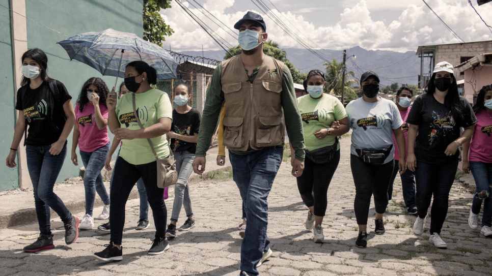 سانتياغو ومتطوعون من منظمة "شباب ضد العنف" يسيرون في أحد أحياء مدينة كوماياغوا الذي تنشط فيه العصابات لتفقد أحوال العائلات هناك
