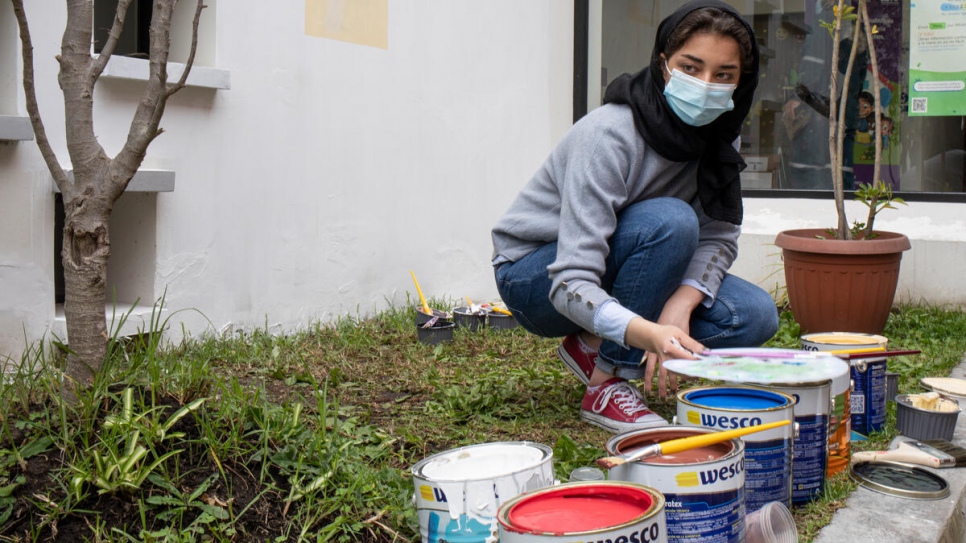 Zohra gets ready to paint a mural on the walls of Quito's Centre for Equality and Justice, where both locals and displaced people receive legal support.