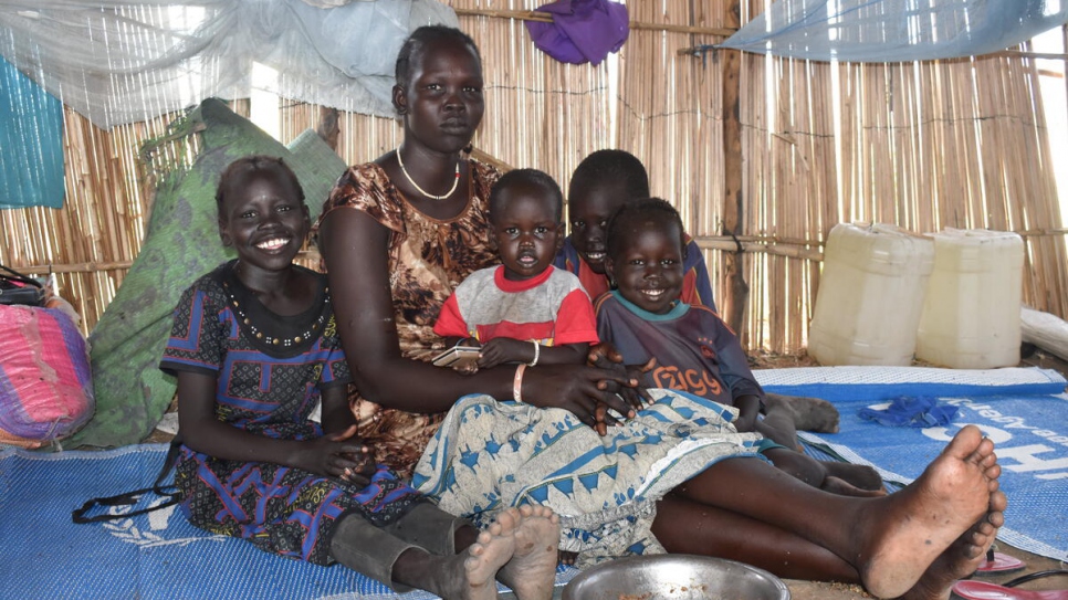 Une famille de réfugiés sud-soudanais assise à l'intérieur d'un abri communautaire après avoir été déplacée du camp d'Alganaa.