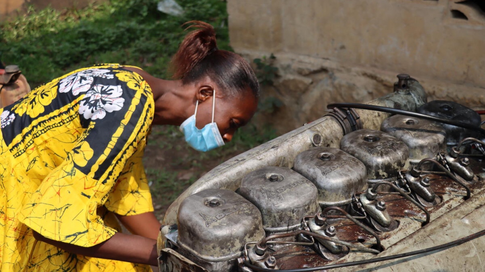 Therese* examine le moteur d'un camion en panne à Kananga, en République démocratique du Congo. 