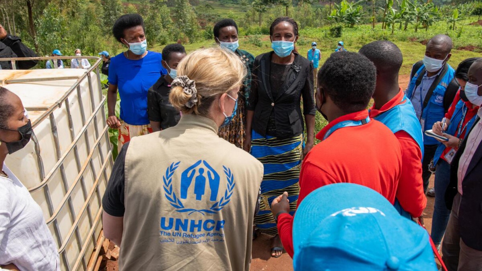 UNHCR Deputy High Commissioner Kelly Clements (centre) chats with Congolese refugee Clementine Bugenimana (in black shirt) at the Misizi marshland project in Mugombwa refugee camp, Rwanda. 