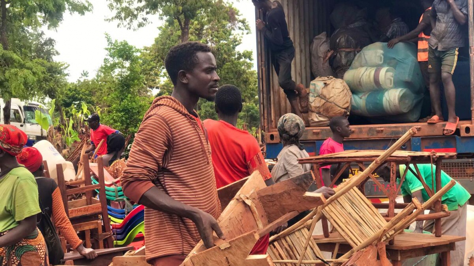 Jambatiste Ntakilumana carries his furniture during the relocation of Burundian refugees from Mtendeli to Nduta refugee camp, Tanzania.