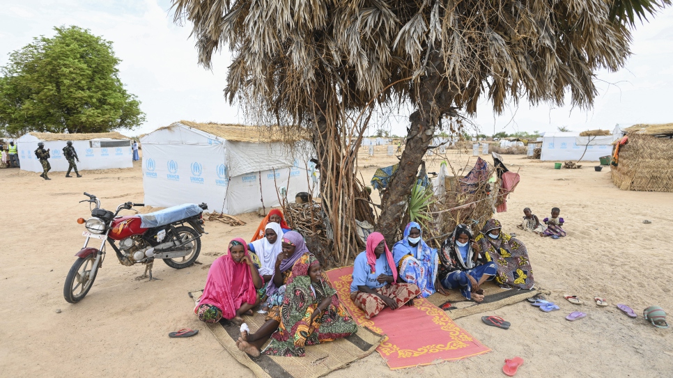 Internally displaced residents sit in the shade of one of the few remaining trees in the Ardjaniré site.