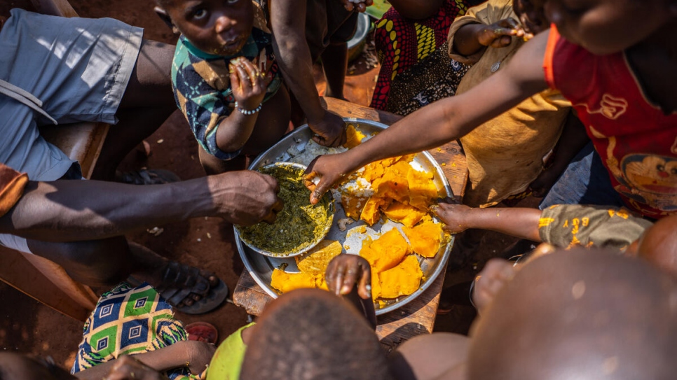 South Sudanese refugee, Justin Ripay's children enjoy a meal he and his wife, Christine prepared after harvesting food from their farm in the Central African Republic. 