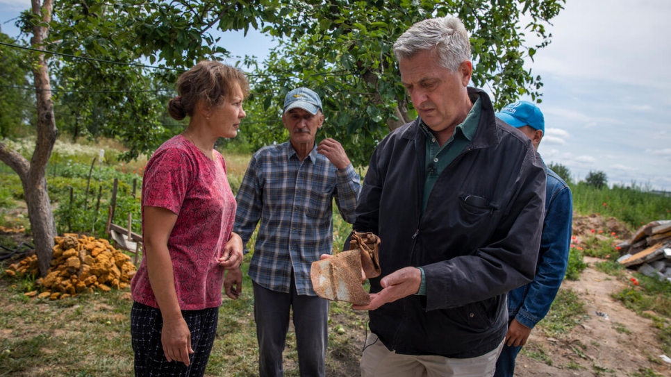 High Commissioner Filippo Grandi holds a piece of the missile that destroyed the family's home.