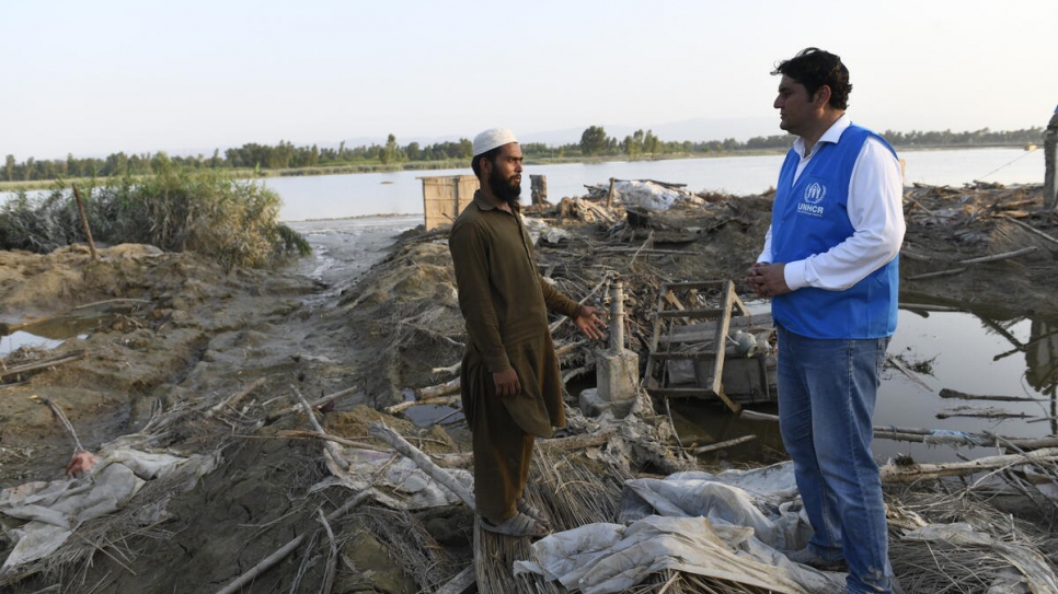 Saleem Khan talks to a UNHCR staff member. His family have received a tent but with their crops destroyed, they lack money to rebuild their home.