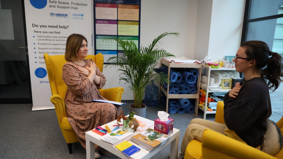 Inna demonstrates a "butterfly hug" as part of a stress relief therapy session at the Blue Dot hub in Warsaw.