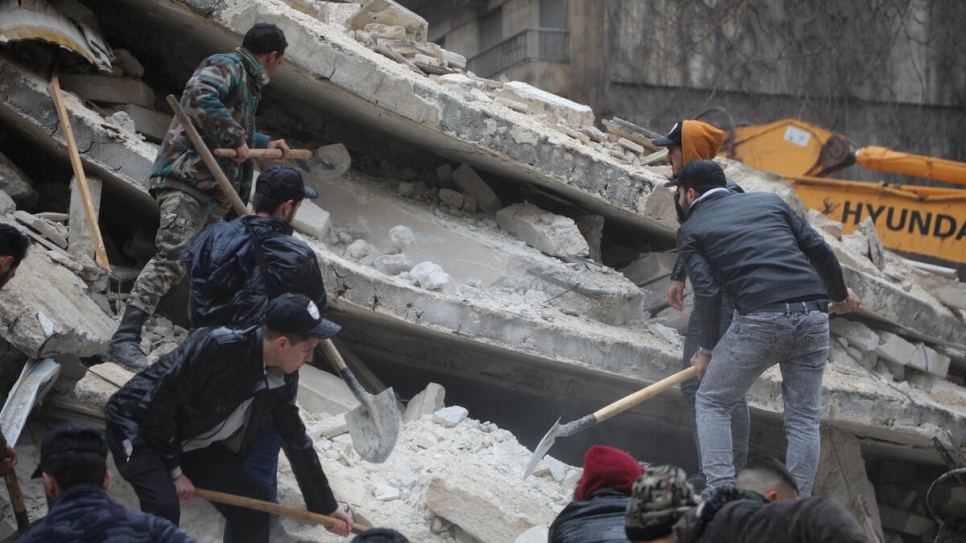 People search for survivors under the rubble of a collapsed building in the Al-Aziziyeh neighborhood of Aleppo, Syria, following two powerful earthquakes that struck the region on 6 February.