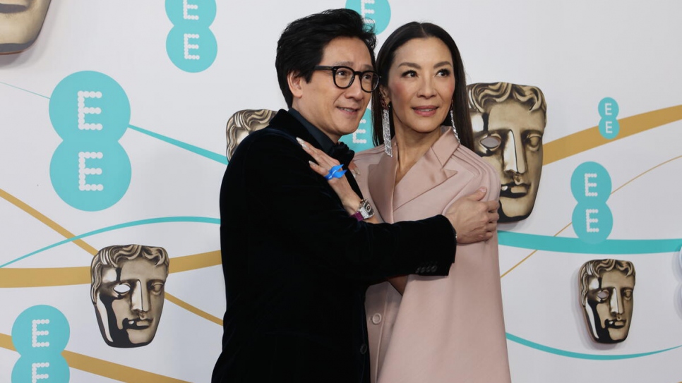 Actors Ke Huy Quan and Michelle Yeoh wearing a blue ribbon in solidarity with refugees at the EE BAFTA Film Awards 2023.