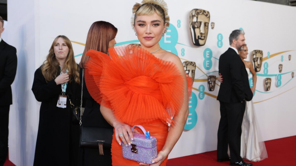 Actor Florence Pugh wearing a blue ribbon in solidarity with refugees at the EE BAFTA Film Awards 2023.