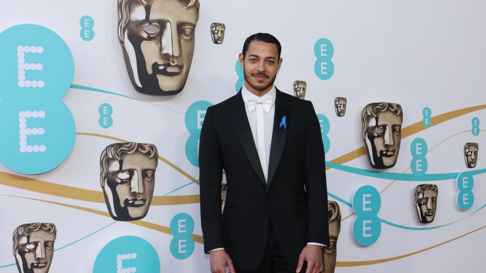 Actor Daryl Mcormack wearing a blue ribbon in solidarity with refugees at the 2023 BAFTA award ceremony.