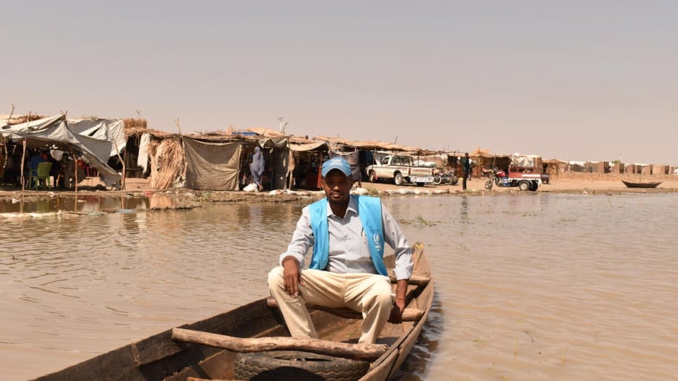 A UNHCR staff member uses a boat to access refugees cut off by the floods.