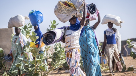 Malian refugee women carrying their belongings through Mbera refugee camp in Mali. UNHCR, UN Refugee Agency, Sexual and Gender-based Violence SGBV GBV