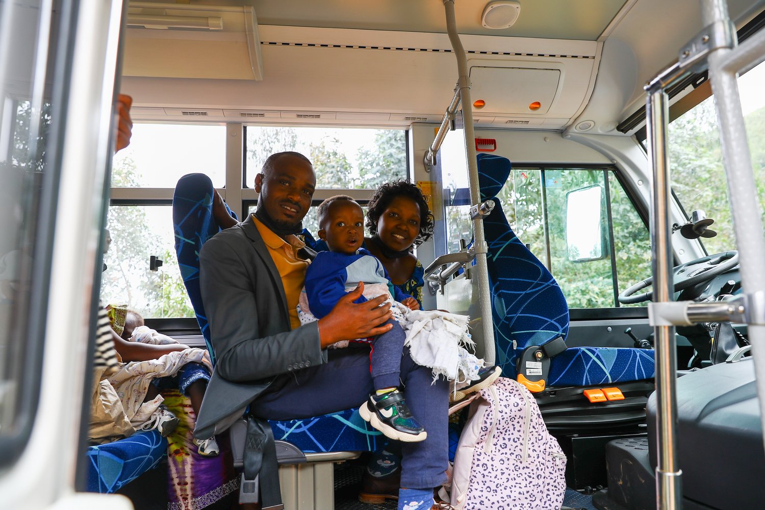A couple and their young son sit in a bus.
