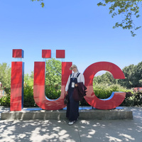 A person stands in front of large red “iuc” letters in an outdoor setting.