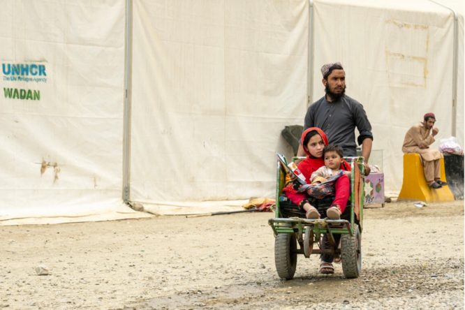 Hadigul is carrying his younger sisters, Sabria and Freshta, as they travel together after recently returning to Afghanistan. Despite the hardships they’ve faced, the close-knit family shows resilience and strength as they move forward.