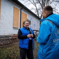 People are standing in front of the damaged building