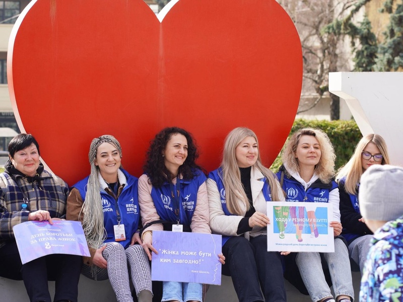 People are sitting on the red bench