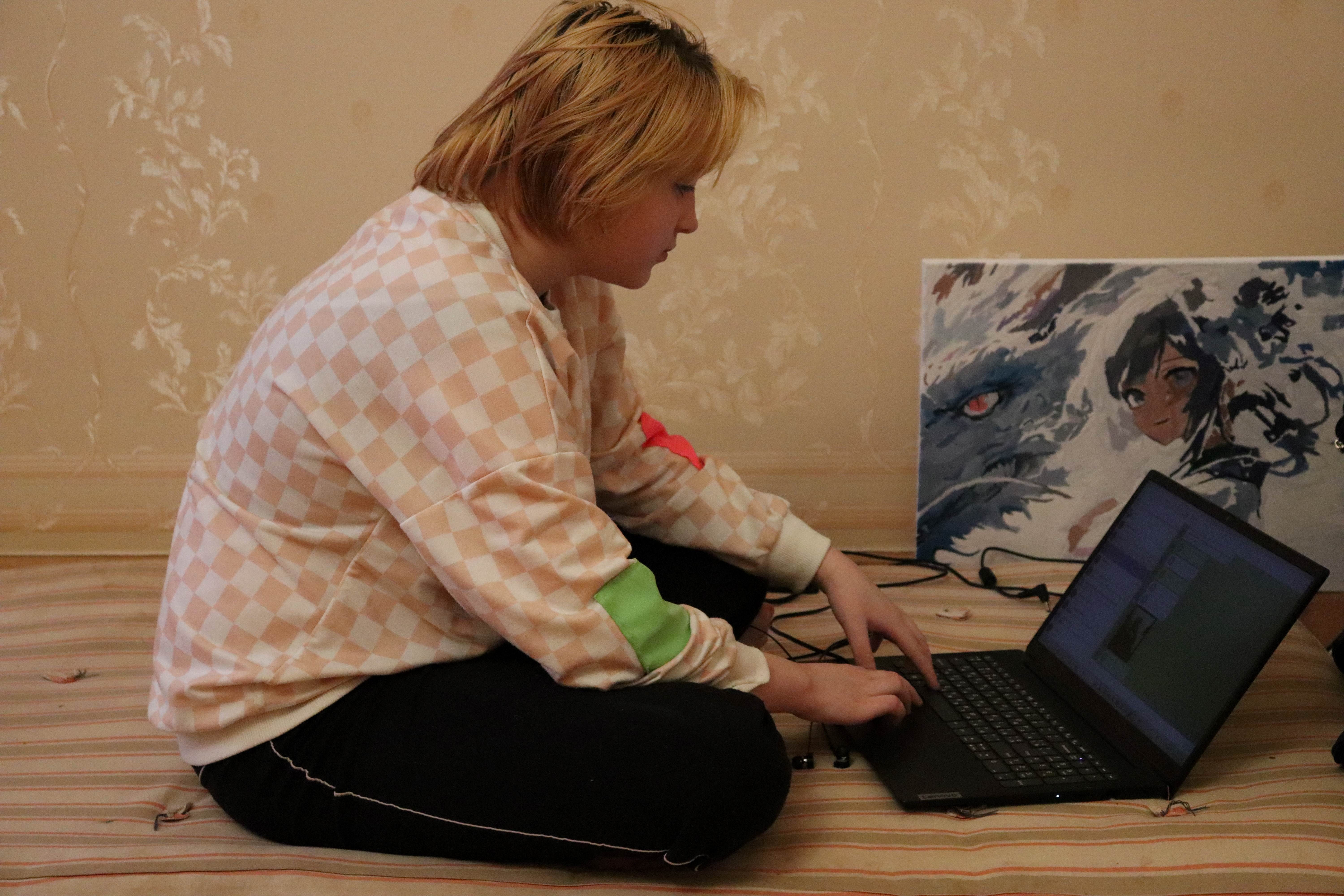 A woman sitting next to the computer