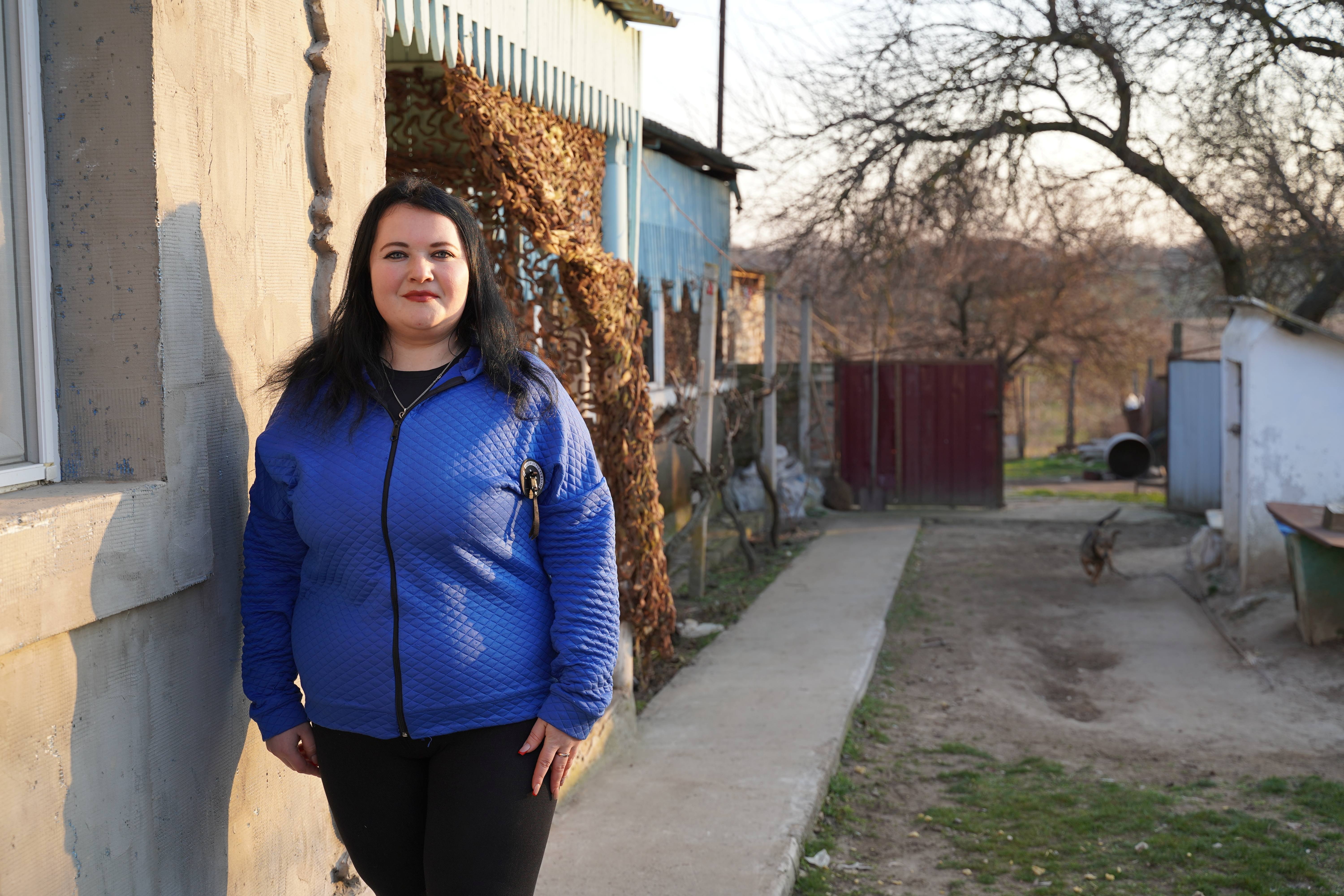 A woman standing in front of her house