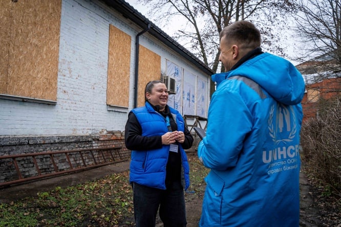 People are standing in front of the damaged building