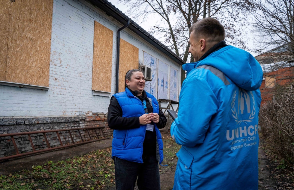 People are standing in front of the damaged building