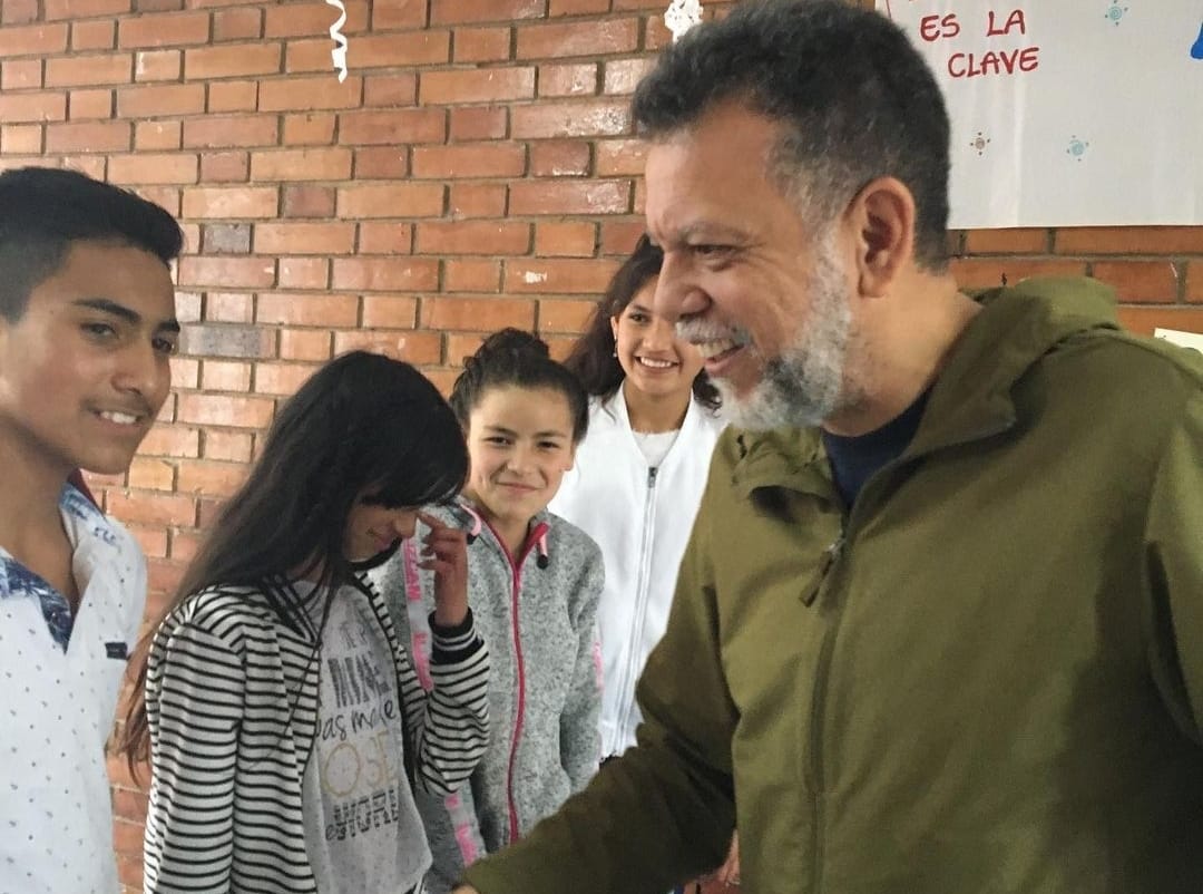 Alberto Dinero talking to a group of children.