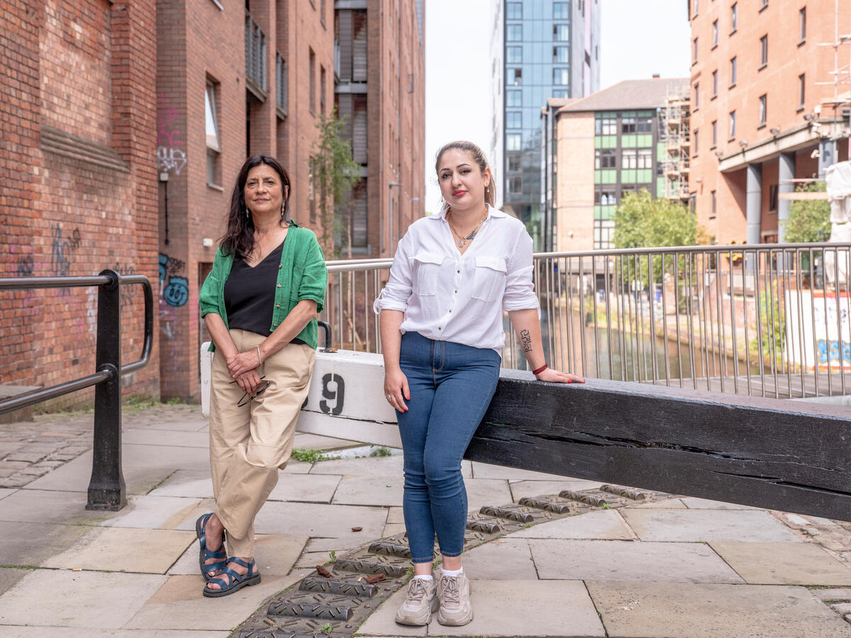 two women pose at a canal