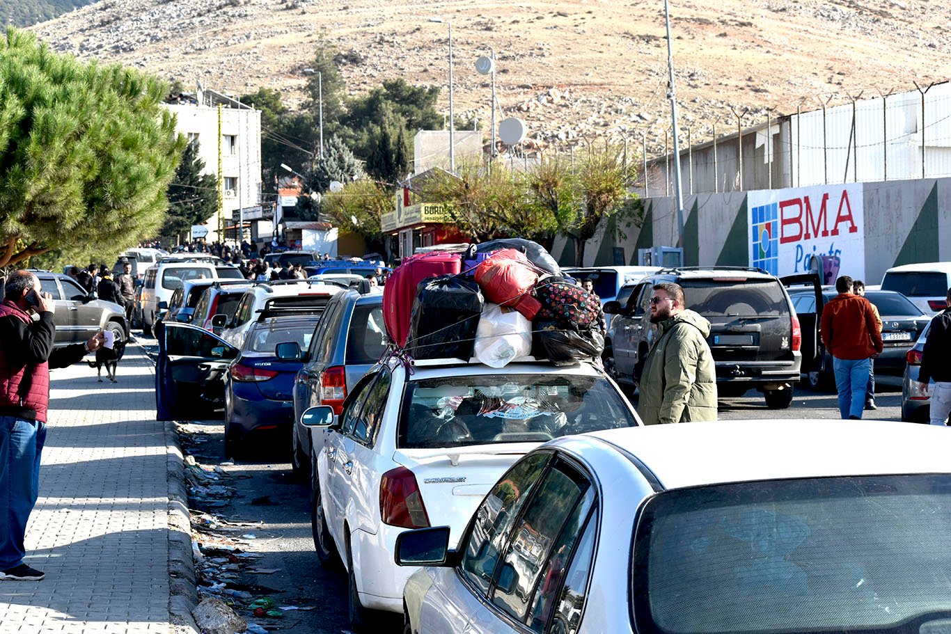 A street filled with lines of vehicles loaded with belongings.